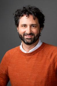 Eric W. Campbell faculty photo A white male with a beard and mustache, orange sweater