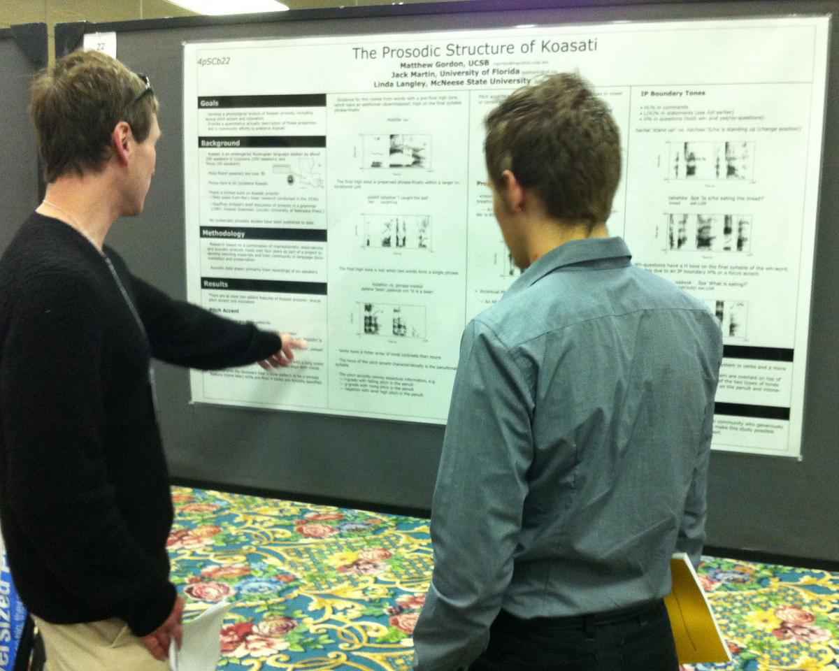 Professor Matthew Gordon and graduate student Joseph Brooks discussing a poster at a conference.